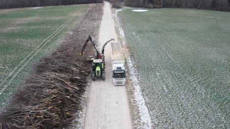 Aerial-view-of-heavy-wood-chipper-machinery-blow-shredded-wood-in-trailer