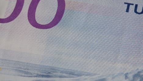 1000-NOK-banknote-moving-close-to-camera,-revealing-1000-number,-macro