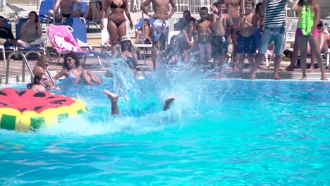 Crowded-Pool-full-of-People-Watching-Man-Balancing-and-Fall-in-Float,-Slow-Motion