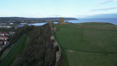 Forward-drone-shot-of-Scarborough-castle-during-sunset-in-Scarborough-North-Yorkshire,-England