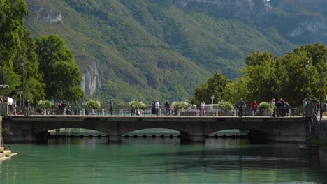 Menschen-Gehen-Auf-Einer-Steinbrücke-über-Thiou,-Wo-Der-Fluss-Durch-Die-Altstadt-Von-Annecy-Fließt