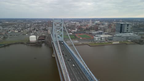 Aerial-drone-video-of-the-Ben-Franklin-Bridge-with-Camden,-New-Jersey-in-the-background