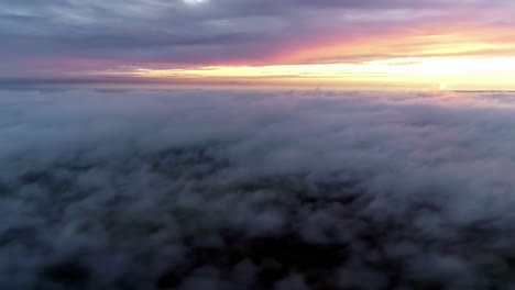 Aerial-above-dramatic-beautiful-golden-sun-sunset-over-thick-clouds