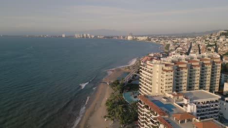 Aerial-Drone-Fly-Beachfront-Puerto-Vallarta-Hotels-in-Mexican-Summer-Beach-Sea-Landscape,-Vibrant-Resort-City-Destination