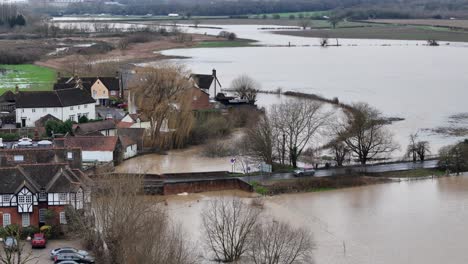 Road-bridge-River-Roding-Abridge-UK-Flooded-river-Roding-pull-back-drone-aerial-reverse-reveal
