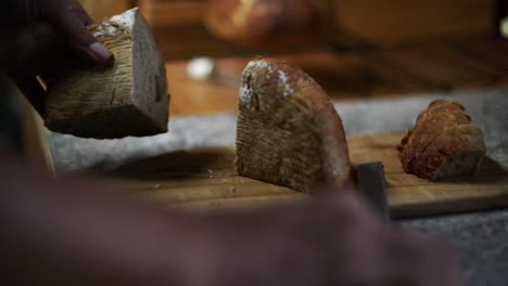 Loaf-of-freshly-baked-bread-cut-in-half-and-separated,-filmed-as-closeup-slow-motion-shot