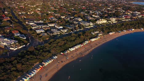 Panning-aerial-footage-of-Brighton's-famous-colourful-bathing-boxes-in-Melbourne,-Australia