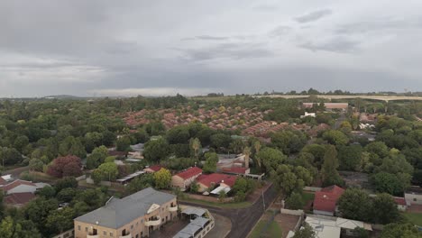 Circular-drone-flight-over-residential-area-with-a-train-bridge-in-Centurion,-South-Africa