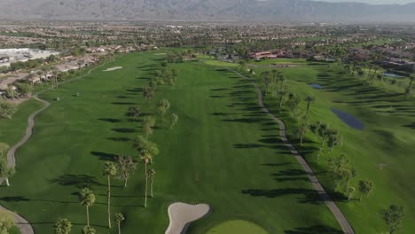 Heritage-Palms-Golf-Course-in-Indio,-California-with-drone-video-pulling-up-from-green-close-view