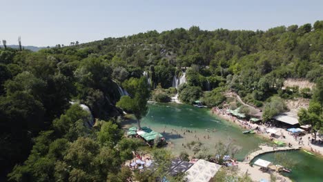 Paradisiac-waterfall-of-Kravica-in-Bosnia-and-Herzegovina,-crowded-lake,-summer