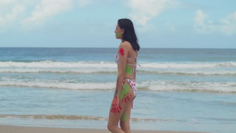 Ein-Sonniger-Karibischer-Tag-Bietet-Den-Perfekten-Rahmen-Für-Ein-Mädchen-In-Körperbemalung-Und-Bikini,-Das-An-Einem-Weißen-Sandstrand-Spaziert