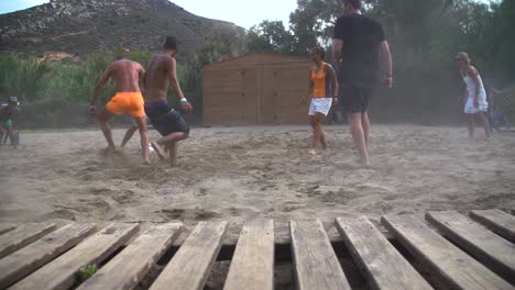 Jóvenes-En-Acción-Dinámica-Jugando-Fútbol-En-La-Arena-De-La-Playa.