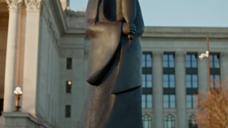 Tilt-up-shot-of-the-As-Long-as-the-Water-Flows-statue-on-the-grounds-of-the-Oklahoma-State-Capitol-building-to-the-capitol-building
