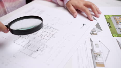 Architect-at-the-construction-site-checks-house-plan-documents-with-a-pencil-to-check-structural-design,-correctness,-and-construction-strength