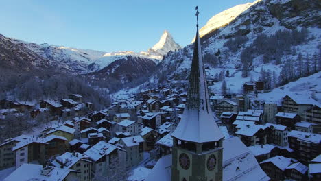 Drone-descends-over-Zermatt-town,-unveiling-intricate-details-of-St