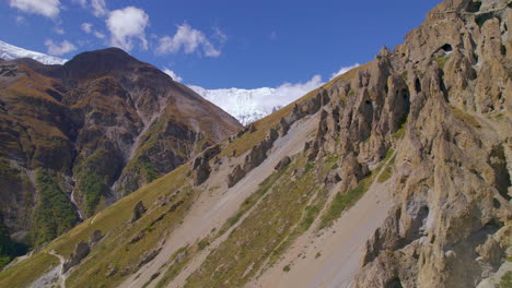 Angenehmes-Sonniges-Wetter-Am-Annapurna-Circuit-Nepal,-Drohnenaufnahme-Einzigartiger-Schlammiger-Hügel,-Wolken-Und-Sichtbarer-Berglandschaft-4k