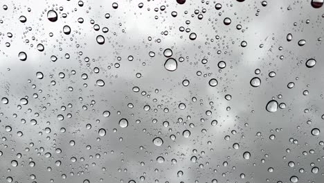 Vertical-wallpaper-Closeup-real-time-raindrops-falling-on-the-glass-on-a-gray-cold-rainy-day