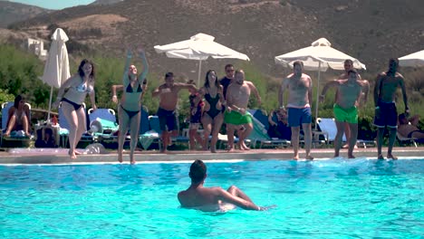 Group-of-Friends-Jumping-into-a-Pool-in-Summer-Holidays,-Slow-Motion