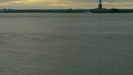 Tilt-Up-from-Waters-of-New-York-Bay-to-Statue-of-Liberty-at-Sunset