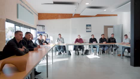 Classroom-full-of-adult-roof-workers-following-training-course,-sitting-and-paying-attention-in-class