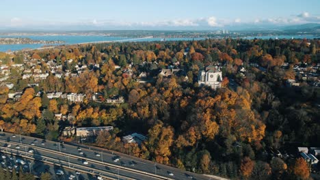 Panoramic-aerial-establishing-view-of-cathedral-on-hilltop-overlooking-Seattle-Washington-highway-at-midday