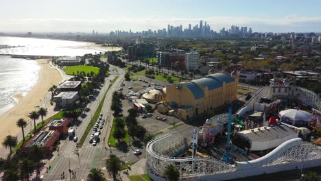 Aerial-footage-flying-past-St-Kilda's-beach-famous-amusement-park,-the-Luna-Park-Melbourne