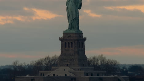 Tilt-Up-from-Liberty-Island-to-Statue-of-Liberty-at-Sunset,-Center-framed