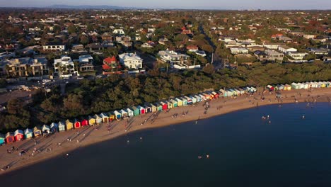 Drone-footage-of-Brighton's-colourful-bathing-boxes-that-attracts-thousands-of-tourists-in-Melbourne,-Australia