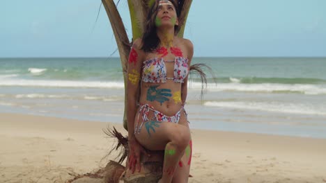 Enjoying-the-Caribbean-sunshine,-a-girl-wears-body-paint-and-a-bikini-on-a-white-sand-beach