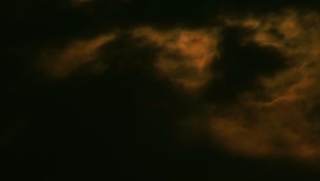 Night-sky-and-orange-light-on-cloudscape-because-of-moon