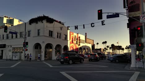Venice-sign-at-the-corner-of-Pacific-Ave---Windward-Ave-with-traffic-,-during-sunset,-in-Los-Angeles,-California,-USA---Static-shot