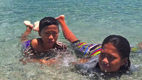 Niños-Filipinos-Tumbados-En-La-Orilla-Rocosa-Y-Disfrutando-De-La-Hermosa-Playa-Durante-El-Verano-En-Filipinas