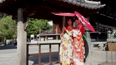 Zwei-Wunderschöne-Geisha-Mit-Roten-Regenschirmen-Am-Tempel