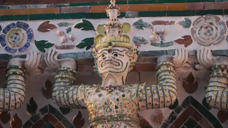 Close-up-shot,-Statue-of-a-demon-supporting-a-prang-at-wat-arun,-in-Bangkok-Thailand