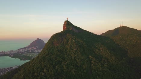 Drohne-Fliegt-Während-Der-Goldenen-Stunde-Auf-Cristo-Redentor-Zu,-In-Der-Ferne-Ist-Die-Stadt-Rio-Zu-Sehen