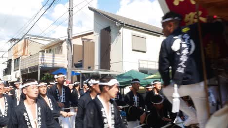 Eine-Gruppe-Traditionell-Gekleideter-Japanischer-Männer-Kommt-Während-Des-Danjiri-Matsuri-Festivals-Auf-Einem-Festwagen-Vorbei