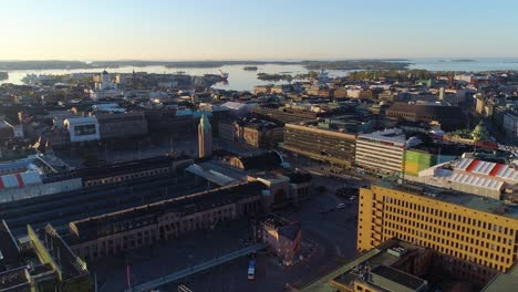 Aerial-view-of-the-Central-Railway-station-on-a-sunny,-summer-sunrise,-in-Downtown-Helsinki,-Finland--,-rising,-drone-shot