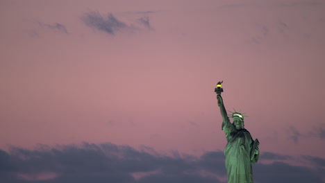 Statue-of-Liberty-with-Lights-on-and-Pink-Sky