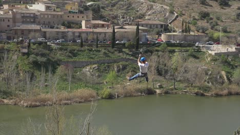 Zoomed-view-of-man-on-zipline-over-a-river