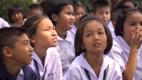Cerca-De-Niños-Tailandeses-Con-Uniformes-De-Escuela-Primaria-Sentados-Afuera-Esperando-Clase,-Bangkok,-Tailandia