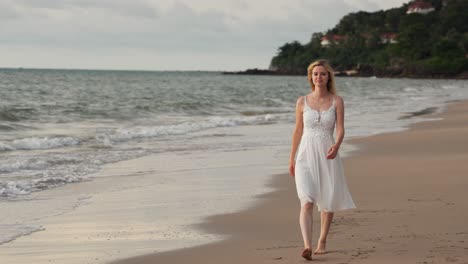 Eine-Zeitlupenaufnahme-Eines-Mädchens-In-Weißem-Kleid,-Das-Bei-Sonnenuntergang-Am-Tropischen-Strand-Spaziert