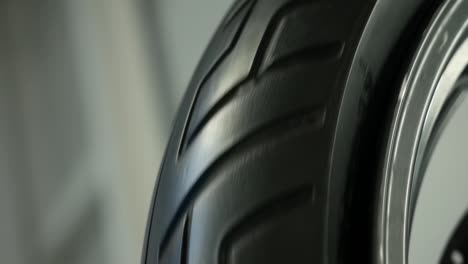 Close-Up-Of-Spinning-Motorbike-Tyre-Inside-Workshop