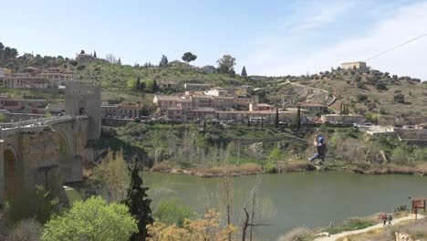 Man-on-ziplane-over-the-river-Tajo-in-the-old-town-of-Toledo-in-Spain