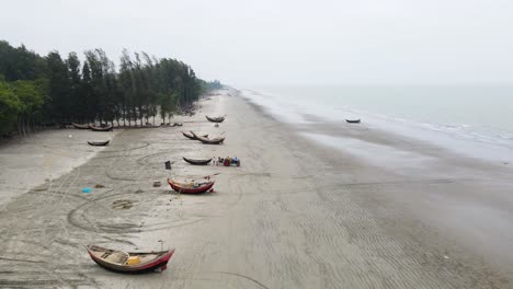 A-group-of-fishermen-and-their-boats-at-beach-along-the-shoreline-preparing-to-go-to-the-sea