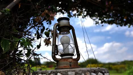 Closeup-Of-Old-And-Rusty-Vintage-Lamp-With-Lightbulb-In-The-Garden