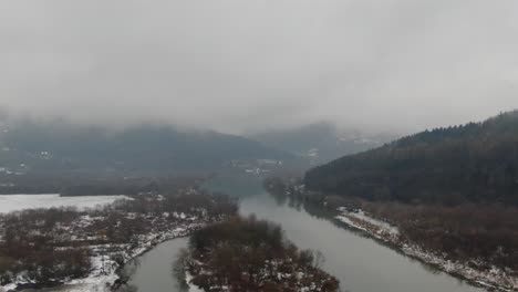 Serene-mountain-river-valley-aerial-panorama-on-cold-winter-stormy-day