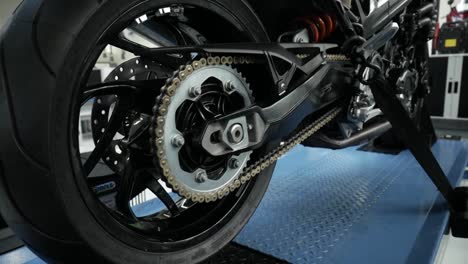 Low-Angle-View-Of-Stationary-Black-Motorcycle-Inside-Workshop