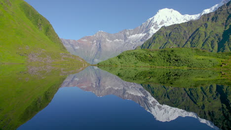 Paisaje-De-La-Montaña-Annapurna-Reflejado-En-El-Lago-Rodeado-De-Nepal-Verde,-Disparo-De-Drones-En-Tiempo-Despejado-4k