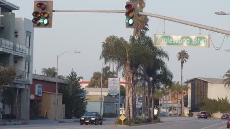 Green-traffic-lights,-on-Inglewood-Blvd-with-traffic,-overcast-day,-in-Los-Angeles,-California,-USA---Static-view