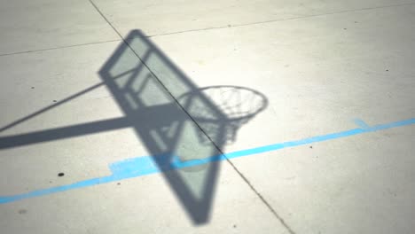 Schatten-Auf-Dem-Betonboden-Des-Basketballkorbs,-Nahaufnahme-Auf-Spielplatzasphalt